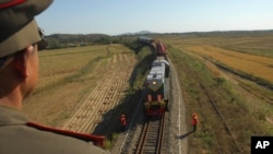 朝鲜军人注视运载帮助朝鲜修建铁路的俄罗斯工人的火车。