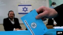 Seorang pemilih memasukkan kertas suaranya ke dalam kotak di sebuah TPS di Bnei Brak, dekat Tel Aviv, Selasa (17/3).