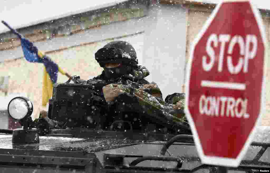 An armed man, believed to be a Russian serviceman, stands guard outside a Ukrainian military base in Perevalnoye,&nbsp; near Simferopol March 16, 2014. 