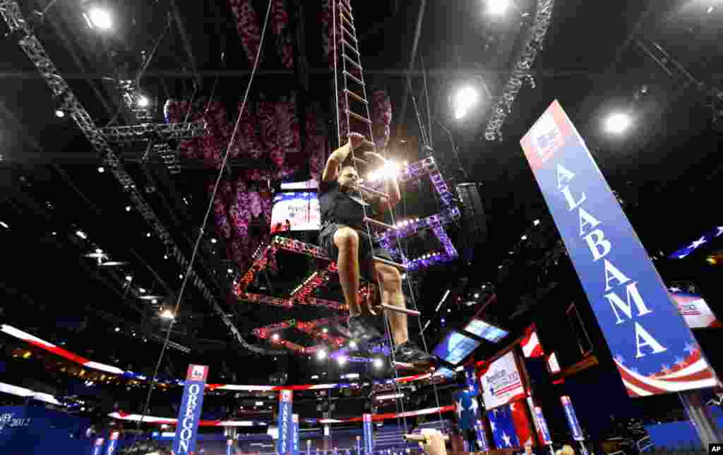 Rigger Omar Acebedo climbs down to the floor of the convention center after adjusting a light fixture.