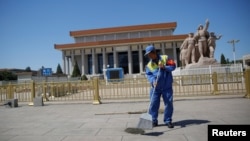 A cleaner sweeps ground in front of the Mausoleum of late Chinese chairman Mao Zedong at Tiananmen Square on the 50th anniversary of the start of the Cultural Revolution in Beijing, China, May 16, 2016.