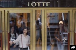 FILE - People come out from Lotte Group office in Seoul, South Korea, Aug. 26, 2016.