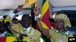 FILE - Zimbabwean President and Zanu PF leader Robert Mugabe (L) and his wife Grace greets delegates during the official opening of the 6th Peoples Congress of Zanu-PF in Harare, Dec. 4, 2014.