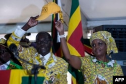 FILE - Zimbabwean President and Zanu PF leader Robert Mugabe (L) and his wife Grace greets delegates during the official opening of the 6th Peoples Congress of Zanu-PF in Harare, Dec. 4, 2014.