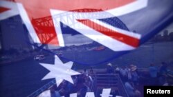 資料照：在悉尼港乘坐渡輪的人們面前飄揚這一面澳大利亞國旗。
