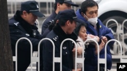 Police officers take away a supporter of rights lawyer Pu Zhiqiang during his trial in Beijing, Dec. 14, 2015.