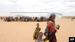 A woman walks with her children to a transit center in the Dolo Ado refugee camp in southern Ethiopia, July 19, 2011.