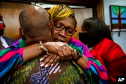 Ahmaud Arbery's mother, Wanda Cooper-Jones, is hugged by a supporter after the jury convicted Travis McMichael in the trial of McMichael, his father, Greg McMichael, and neighbor, William "Roddie" Bryan, Nov. 24, 2021, in the Glynn County Courthouse in Br