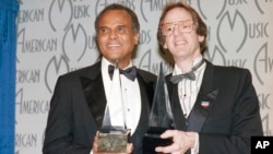FILE - Singer Harry Belafonte, left, and Ken Kragen display their special awards presented to them in Los Angeles, on Jan. 28, 1986, for their efforts in the USA For Africa project and the hit song 'We Are The World.'