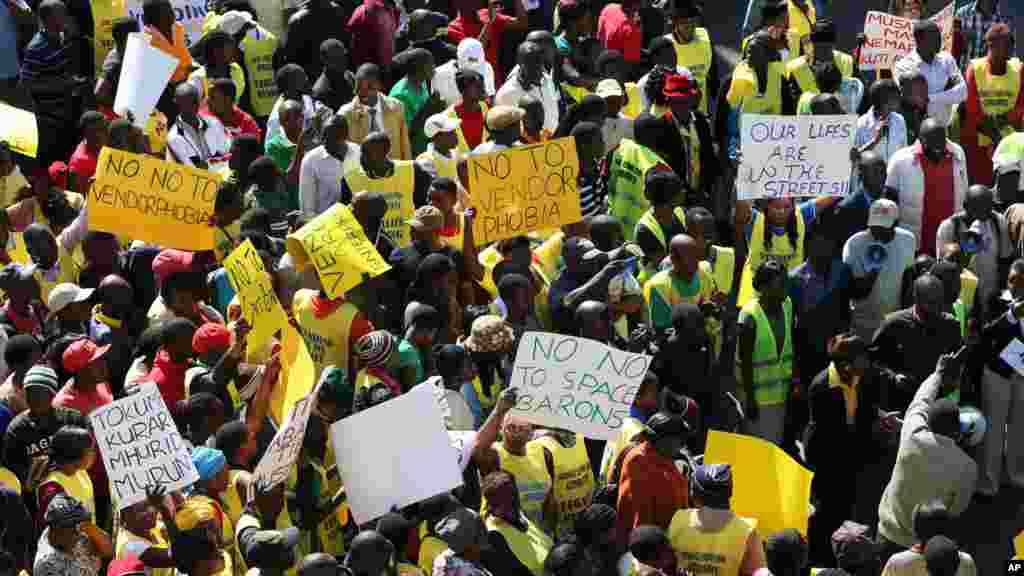 Des vendeurs de rue zimbabwéennes tiennent des banderoles, lors d&#39;une manifestation à Harare, exhortant le gouvernement à cesser de les chasser, le mercredi juin 24, 2015