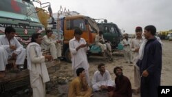 Drivers of oil tankers, which were used to transport NATO fuel supplies to Afghanistan, gather next to their tankers parked in Karachi, Pakistan, July 4, 2012