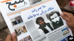 FILE - An Afghan man reads a local newspaper carrying a headline about the appointment of Mullah Akhtar Mansoor as the new leader of the Afghan Taliban, in Kabul, Afghanistan, Aug. 1, 2015. Mansoor was killed in a U.S. drone strike May 21.