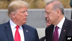 President Donald Trump, left, talks to Turkish President Recep Tayyip Erdogan, right, as they tour the new NATO headquarters in Brussels, Belgium, July 11, 2018. 