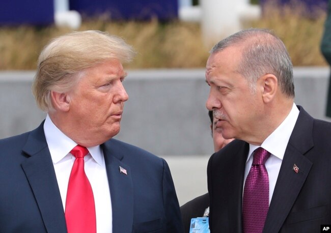 President Donald Trump, left, talks to Turkish President Recep Tayyip Erdogan, right, as they tour the new NATO headquarters in Brussels, Belgium, July 11, 2018.