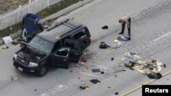 A law enforcement officer looks over the evidence near the remains of a SUV involved in the Wednesdays attack is shown in San Bernardino, California, Dec. 3, 2015. 