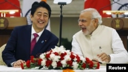 Japan's Prime Minister Shinzo Abe, left, and his Indian counterpart, Narendra Modi, share a moment during a signing of agreement at Hyderabad House in New Delhi, India, Dec. 12, 2015.