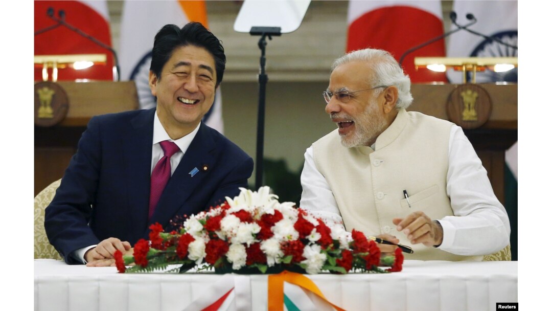 Japan's Prime Minister Shinzo Abe, left, and his Indian counterpart, Narendra Modi, shares a moment during a signing of agreement at Hyderabad House in New Delhi, India, Dec/ 12, 2015.