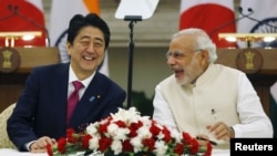 Japan's Prime Minister Shinzo Abe, left, and his Indian counterpart, Narendra Modi, shares a moment during a signing of agreement at Hyderabad House in New Delhi, India, Dec/ 12, 2015. 