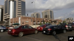 FILE- Cars line up in front of the Nigerian National Petroleum Corporation headquarters to buy fuel in Abuja, May 26, 2015. The global drop in the price of crude has battered Nigeria’s economy, slowing economic growth and cutting into government revenue, March 1, 2016. 