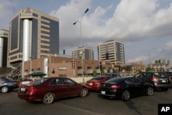 FILE- Cars queue in front of the Nigerian National Petroleum Corporation headquarters to buy fuel in Abuja, Nigeria, May 26, 2015.