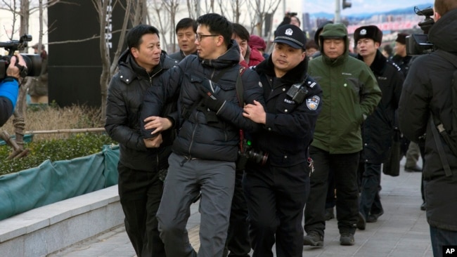 资料照:在北京法院外面拍摄“新公民运动”发起人许志永等人的外国摄影记者被警察架走(2014年1月26日)