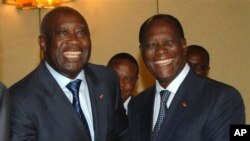 FILE: Then-Ivory Coast President Laurent Gbagbo, left, and opposition presidential candidate Alassane Ouattara pose together for photographers at the Presidential Palace in Abidjan, Ivory Coast, Saturday, Nov. 27, 2008.