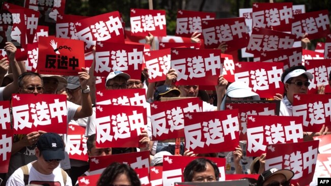 抗議者2019年6月9日在香港參加集會反對有爭議的引渡法案, 會場上有一片「反送中」口號。