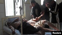 Injured Shi'ite Muslim men are seen in a hospital after a remote control bomb blast took place near a Shi'ite procession in Dera Ismail Khan in Pakistan's northwest, November 25, 2012.