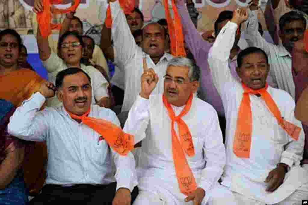 India's main opposition Bhartiya Janta Party (BJP) state of Gujarat President R C Faldu (C) sits with other BJP supporters during a rally to support anti-corruption crusader Anna Hazare in Ahmedabad on August 17, 2011. Indian premier Manmohan Singh slamm