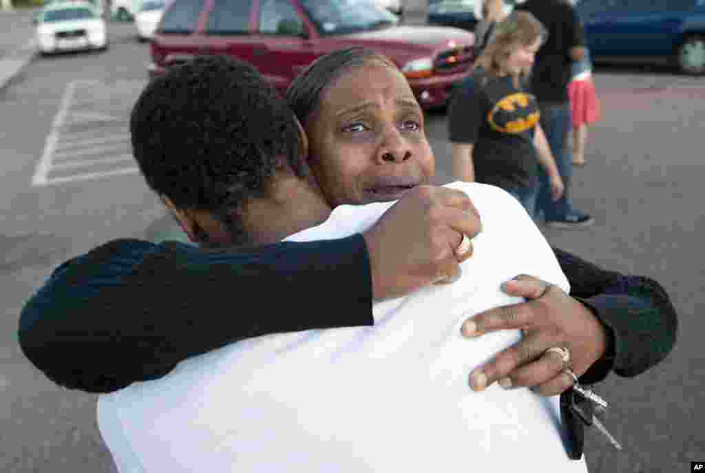Shamecca Davis memeluk putranya, Isiah Bow, seorang saksi mata penembakan, di luar Gateway High School, di mana saksi dipanggil untuk menjawab pertanyaan dari pihak berwajib di Denver, Colorado (20/7).