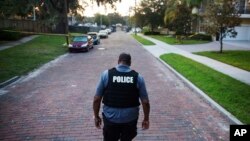 Un oficial de policía camina hacia el lugar de un crimen en Florida. Cuatro oficiales fueron baleados en dos incidentes separados en Florida el viernes, 18 de agosto de 2017.
