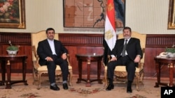 Iran's President Mahmoud Ahmadinejad and Egyptian President Mohamed Morsi pose for photographers in Cairo, Egypt, February 5, 2013. (Egyptian Presidency Handout)