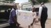 FILE - Congolese Health Ministry officials carry the first batch of experimental Ebola vaccines in Kinshasa, Democratic Republic of Congo, May 16, 2018.