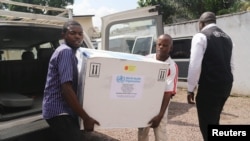 Congolese Health Ministry officials carry the first batch of experimental Ebola vaccines in Kinshasa, Democratic Republic of Congo, May 16, 2018.