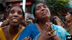 Indian women cry at the site of a building collapse where their relatives are stuck inside the debris, in Secunderabad outside Hyderabad, India, July 8, 2013.