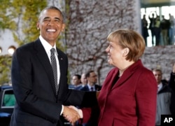 U.S. President Barack Obama, left, is welcomed by German Chancellor Angela Merkel prior to a meeting of the government heads of Germany, France, Italy, Spain and Britain in Berlin, Nov. 18, 2016.
