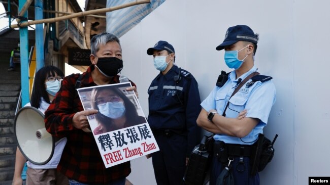 Pro-democracy supporters protest for the release of 12 Hong Kong activists arrested as they reportedly sailed to Taiwan and for citizen journalist Zhang Zhan, outside China's Liaison Office, in Hong Kong, China December 28, 2020. 
