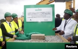 Ivory Coast Prime Minister Daniel Kablan Duncan (R), Roland Pirmez, Heineken International president for Africa, Middle East and Easten Europe, (2nd L) and Marc Bandelier, chief operating officer of CFAO react after unveiling the foundation stone for a new brewery in Abidjan, Sept. 25, 2015.