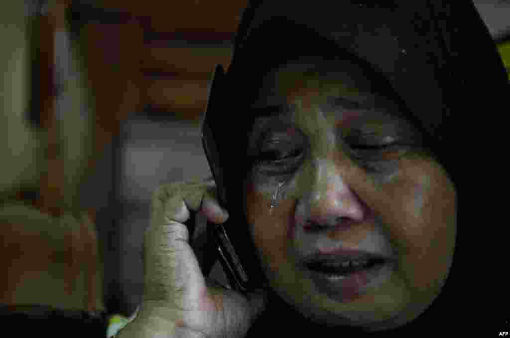 Kerabat dari Norliakmar Hamid dan Razahan Zamani, para penumpang dalam pesawat Malaysia Airlines Boeing 777-200 yang hilang, menangis menanti kabar di Kuala Lumpur.