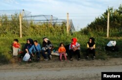 A group of migrants rest on the Serbian side of the border near Sid, Croatia September 16, 2015.