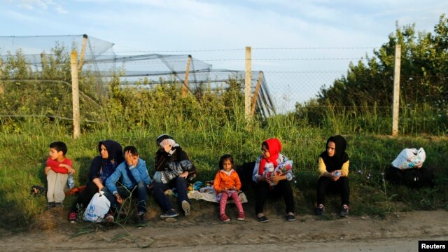 Un grupo de migrantes descansan en el lado serbio de la frontera, cerca de Sid, Croacia, el miércoles 16 de septiembre de 2015.