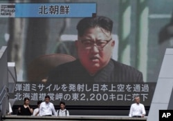 FILE - People walk past a public TV screen showing a file footage of North Korean leader Kim Jong Un during news on North's missile launch, in Tokyo, Sept. 15, 2017.