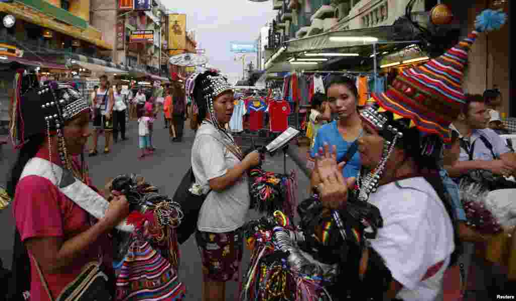 Para pedagang menjual cenderamata di wilayah turis di Jalan Khao San Road di Bangkok (27/5). Pemberlakuan darurat militer merupakan pukulan baru bagi industri pariwisata negara itu, menambah derita ekonomi akibat protes selama enam bulan. (Reuters/Erik De Castro)