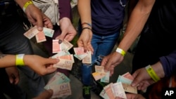 Turista muestra billetes de Bolívar viejos para ser utilizados como boletos para canjear por comida durante un recorrido organizado por Cumbe Tour, del barrio San Agustín de Caracas. Agosto 21, 2021.