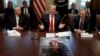 President Donald Trump, with a poster of himself laid out in front of him, speaks during a cabinet meeting at the White House, in Washington, Jan. 2, 2019. 