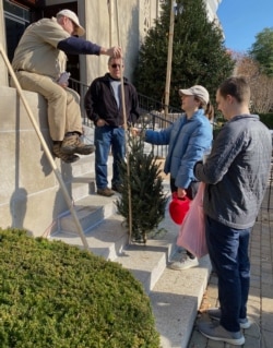 Del Voss measures the height of a Christmas tree at a sale in Washington, D.C.'s Capitol Hill neighborhood.