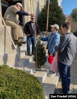 Del Voss measures the height of a Christmas tree at a sale in Washington, D.C.'s Capitol Hill neighborhood.