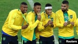 FILE - Neymar, second from right, and his Brazil teammates pose with their gold medals after defeating Germany to win the Olympics soccer final in Rio de Janeiro, Brazil, Aug. 20, 2016.