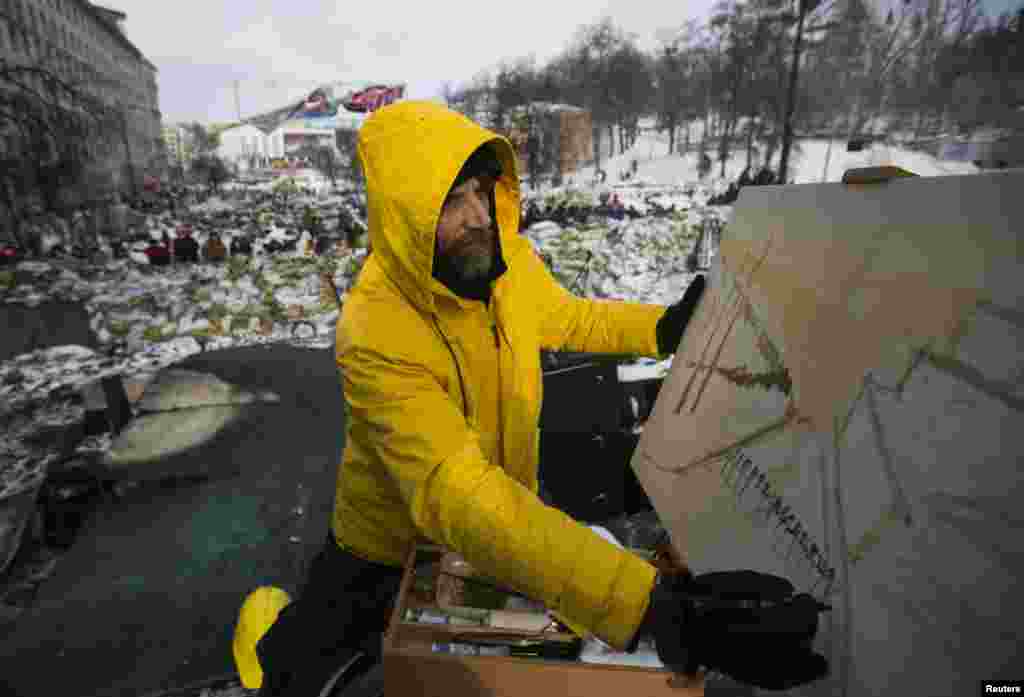 هنرمندی در حال نقاشی در محلی که پیشتر بین پلیس ضدشورش و مخالفان درگیری رخ داد - کیف، ۲۹ ژانویه ۲۰۱۴