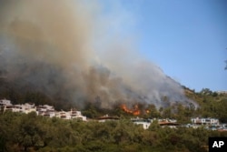 Wildfires rage Cokertme village, near Bodrum, Mugla, Turkey, Tuesday, Aug. 3, 2021. (AP Photo/Emre Tazegul)